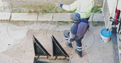 Workers insert fiber optic cables into the underground cable ducts to create  Video stock 196940862