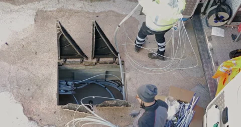 Workers insert fiber optic cables into the underground cable ducts to create  Vídeo Stock 201024708
