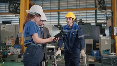 Workers inspect machinery in a bustling factory floor Stock Footage 341925564