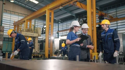 Workers inspect machinery in a bustling factory floor Stock Footage 341925604