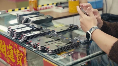 Workers inspecting and testing smartphone screen modules on assembly line in Stock Footage 328963280