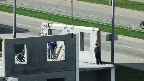 Workers Install Concrete Panel On Building Site. Crane Lowers Prefabricated Wall Stock Footage 325298472