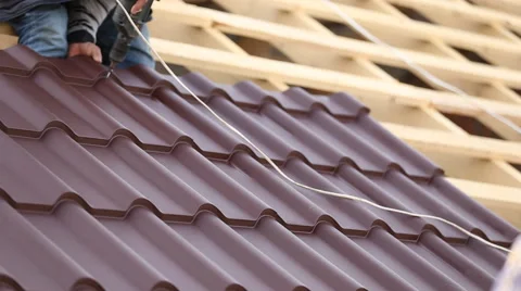 Workers install metal roofing Stock Footage