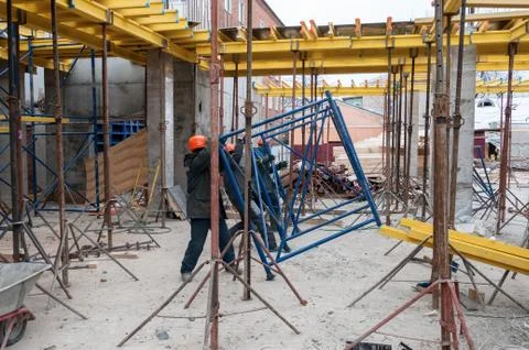 Workers install metal structures at the construction site Stock Photos