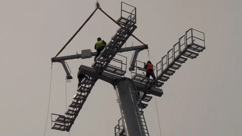 Workers to install multi-ton metal structure on support of cable car. Stock Footage 106553174