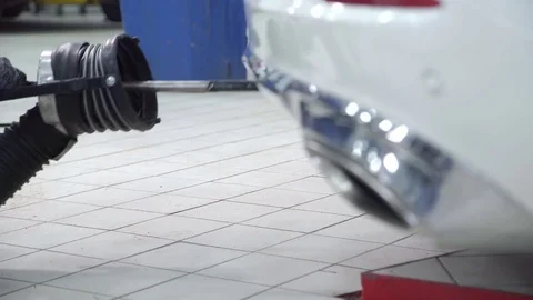 Workers install pipe to exhaust outlet of cars indoors Stock Footage 71511575