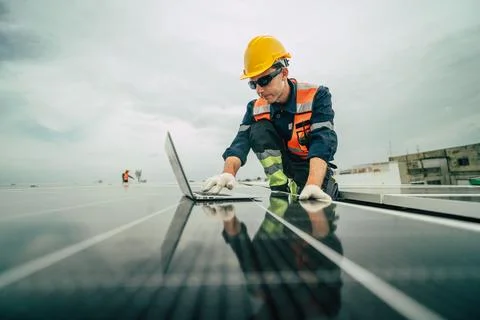Workers install solar panels and perform maintenance on a rooftop while usi.. Stock Photos