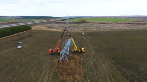 Workers install support of high voltage line on field Stock Footage 90600879