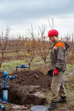 Workers install a water intake unit in a well. Installation of the walls of.. Fotos de archivo