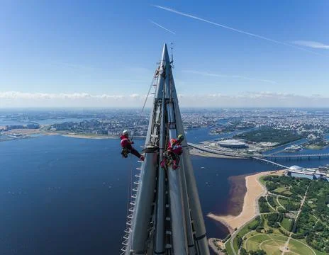 Workers installers at the height work at the top of skyscraper. Stock Photos