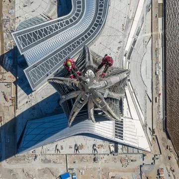 Workers installers at the height work at the top of skyscraper. Stock Photos