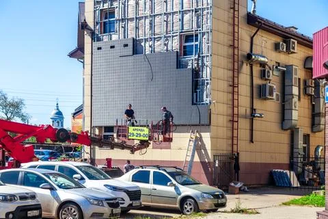 Workers installing building facade using bucket truck Stock Photos