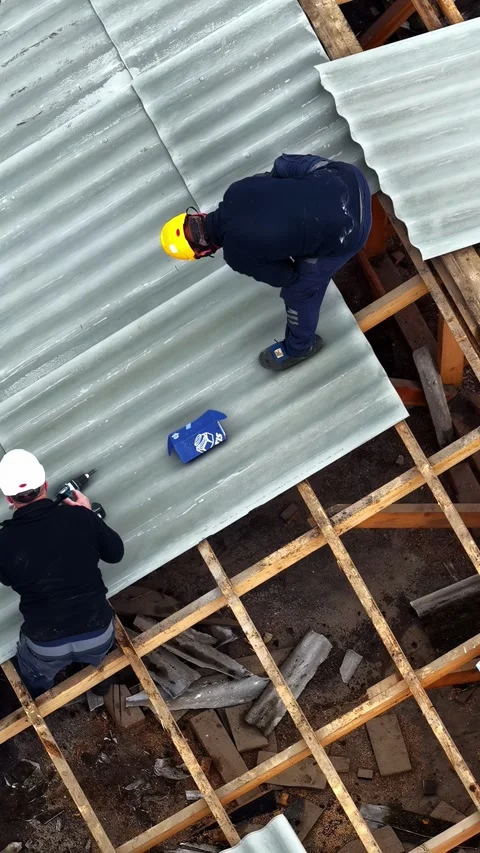 Workers Installing Metal Roofing Panels on Construction Site Stock Footage 335980242