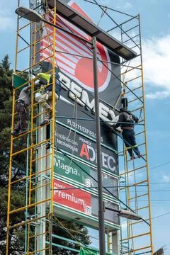 Workers installing pemex gas station sign Fotos de archivo