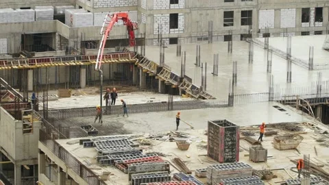 Workers at large construction site pour and level concrete. Modern monolithic Stock Footage 142934015