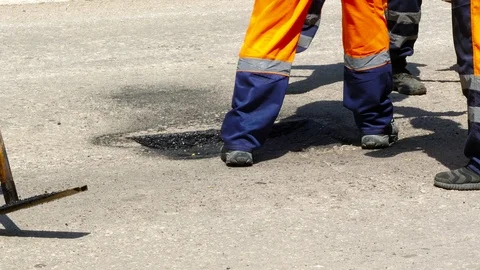 Workers lay asphalt in a hole in the road surface Stock Footage 87955927