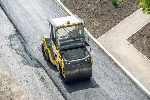 Workers lay a new asphalt coating using hot bitumen. Work of heavy machiner.. Stock Photos