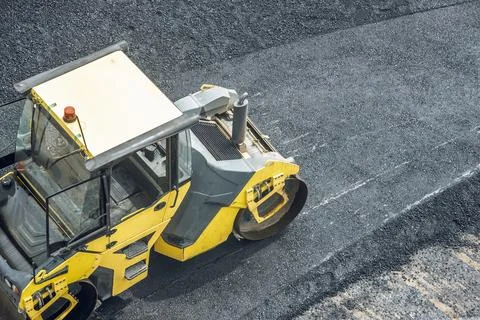 Workers lay a new asphalt coating using hot bitumen. Work of heavy machiner.. Stock Photos