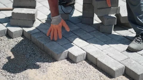 Workers lay paving tiles, construction of brick pavement, close up architectu Stock Footage 167709911