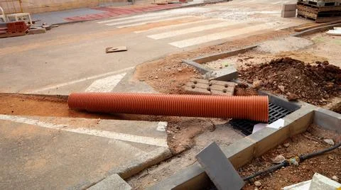 Workers laying communications infrastructure during street repair in urban ar Stock Photos