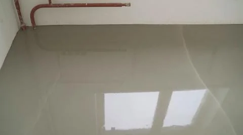 Workers level the floor with mortar. Self-priming liquid floor. Adjust the mixed Stock Photos