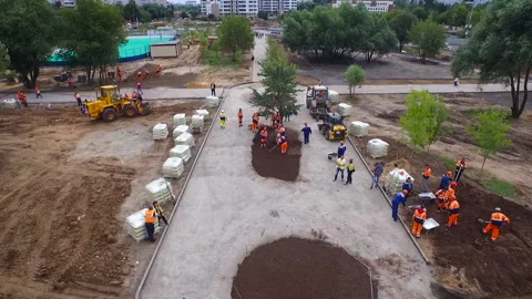 Workers level the ground in the park. Building in the city center. Stock Footage 93809905