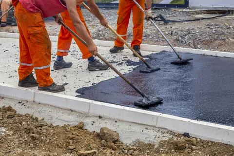 Workers leveling hot asphalt Stock Photos