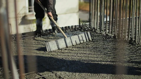 Workers leveling wet concrete on construction site Stock Footage 300336959