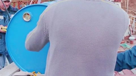 Workers load big blue barrels on board of tug. Work process at river port. Stock Footage 154294305