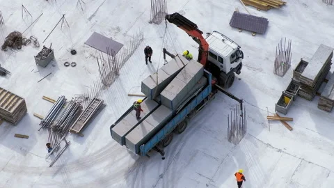 Workers load a concrete block on a small truck crane at the construction site Video stock 236473927