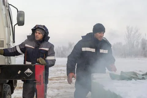 Workers load ice blocks from a car 스톡 사진