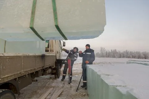 Workers load ice blocks from a car 스톡 사진