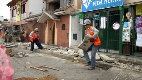 Workers loading and pulling concrete debris from demolished sidewalk for fiber Stock Footage 160376973