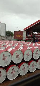 Workers loading and unloading Pertamina oil in containers Stockfoto's