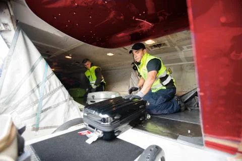 Workers Loading Luggage In Airplane Stock Photos