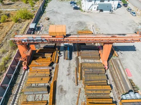 Workers loading stack of metal pipes with gantry crane Stock Photos
