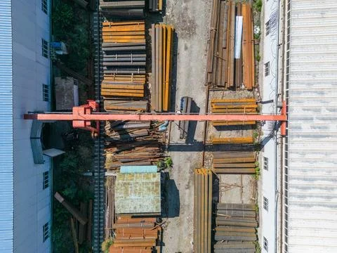 Workers loading stack of metal pipes with gantry crane Stock Photos