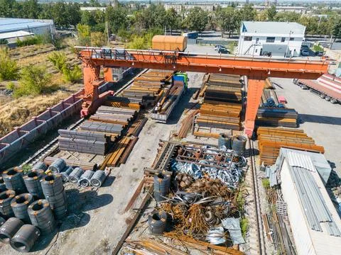 Workers loading stack of metal pipes with gantry crane Stock Photos