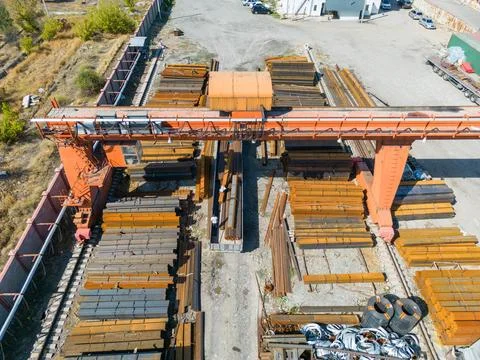 Workers loading stack of metal pipes with gantry crane Stock Photos