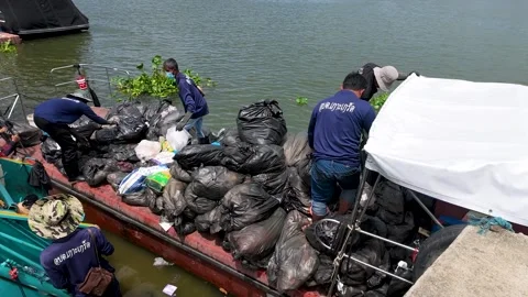 Workers Loading Trash Bags from Boat into Garbage Truck on River Stock Footage 339514069