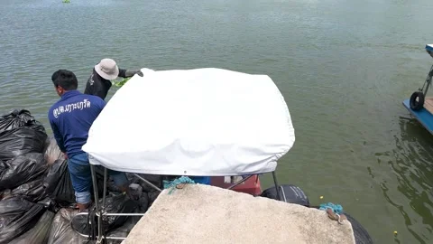 Workers Loading Trash Bags onto a Garbage Boat on a River Stock Footage 340135079