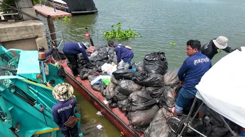 Workers Loading Trash Bags Onto Waste Management Boat on River Stock Footage 340244040