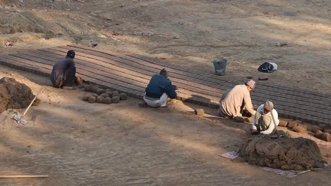 Workers at a local brick factory making bricks in broad day light. Stock Footage 86657723