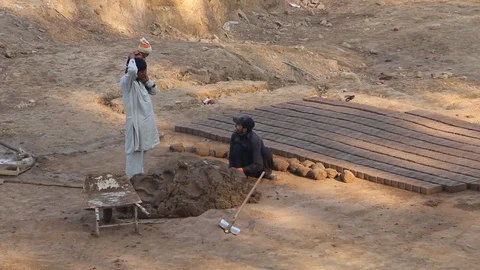 Workers at a local brick factory making bricks in broad day light. Stock Footage 86657784