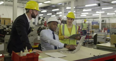 Workers look at laptop computer in shipping warehouse. Stock Footage