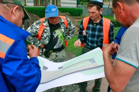 Workers look at the map, work discussion Stock Photos