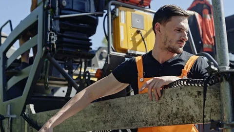 Workers manages a machine that puts asphalt evenly on the road surface. Stock Footage 97667045