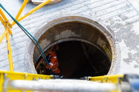Workers in a manhole Stock Photos