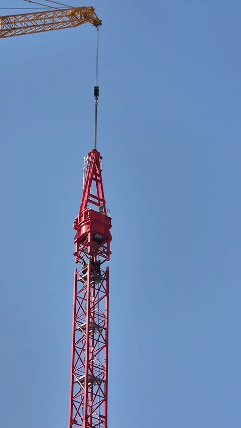 Workers Manually Aligning Tower Crane Top Section with Mast Stock Footage 334599608