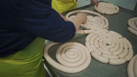 Workers in meat factory forming many short sausages from one long sausage. Sausa Stock Footage 131864837